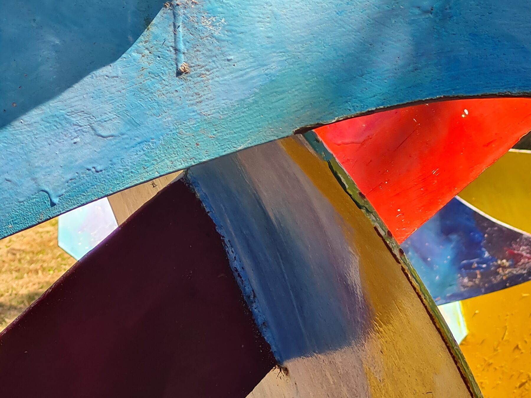 Nahaufnahme eines abstrakten, farbigen Kunstwerks mit gebogenen Flächen in Blau, Rot, Gelb und Schwarz